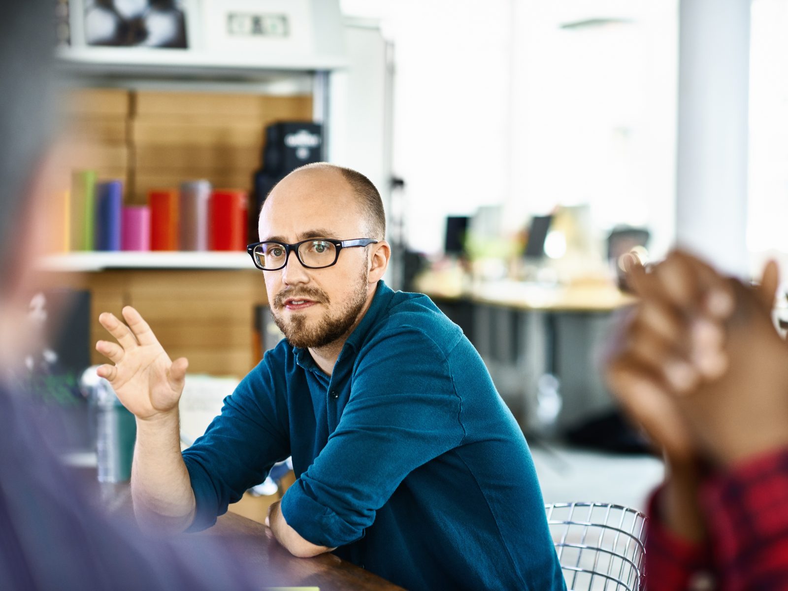 Man presenting to colleagues in a relaxed meeting