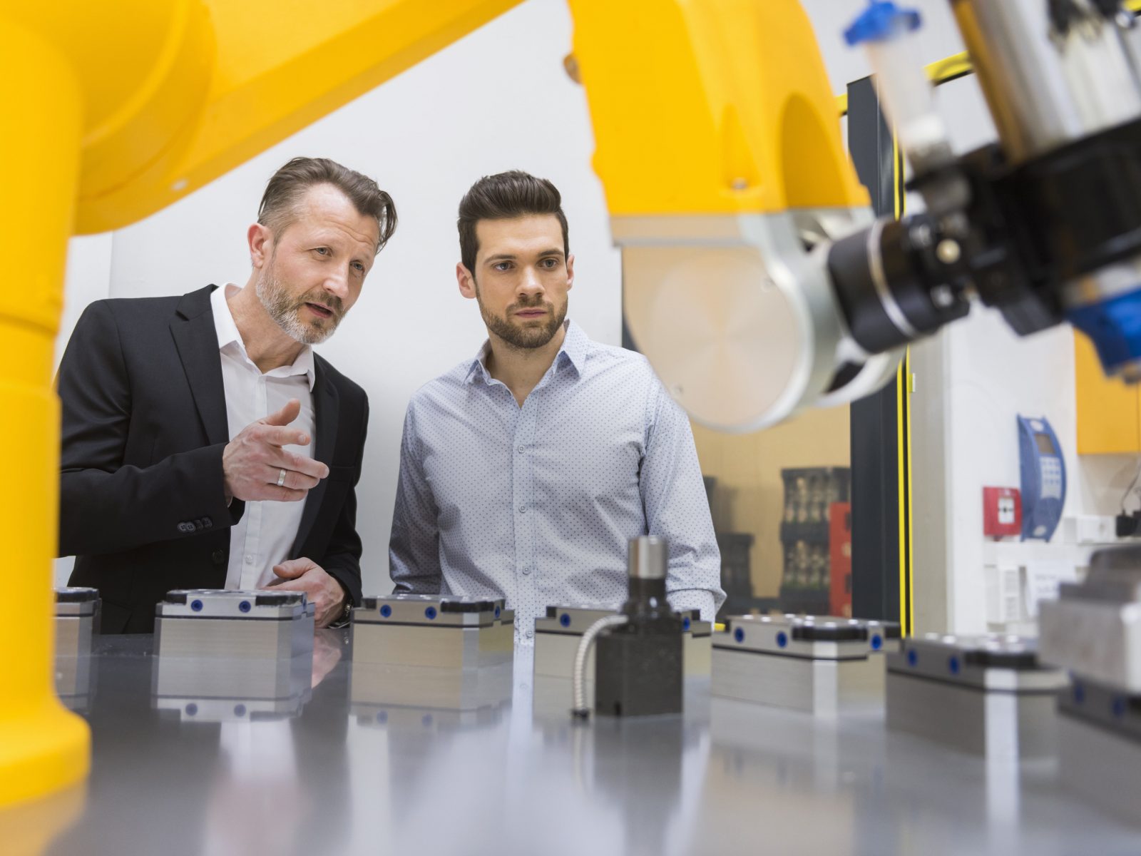 Two men working in laboratory with a robotic arm