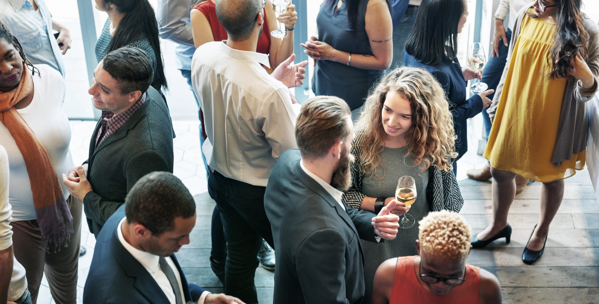 Aerial view of a conference event. Centered man and woman talking and drinking wine
